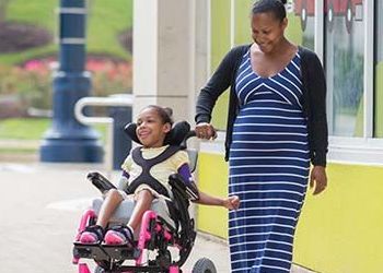woman walking with daughter with wheelchair